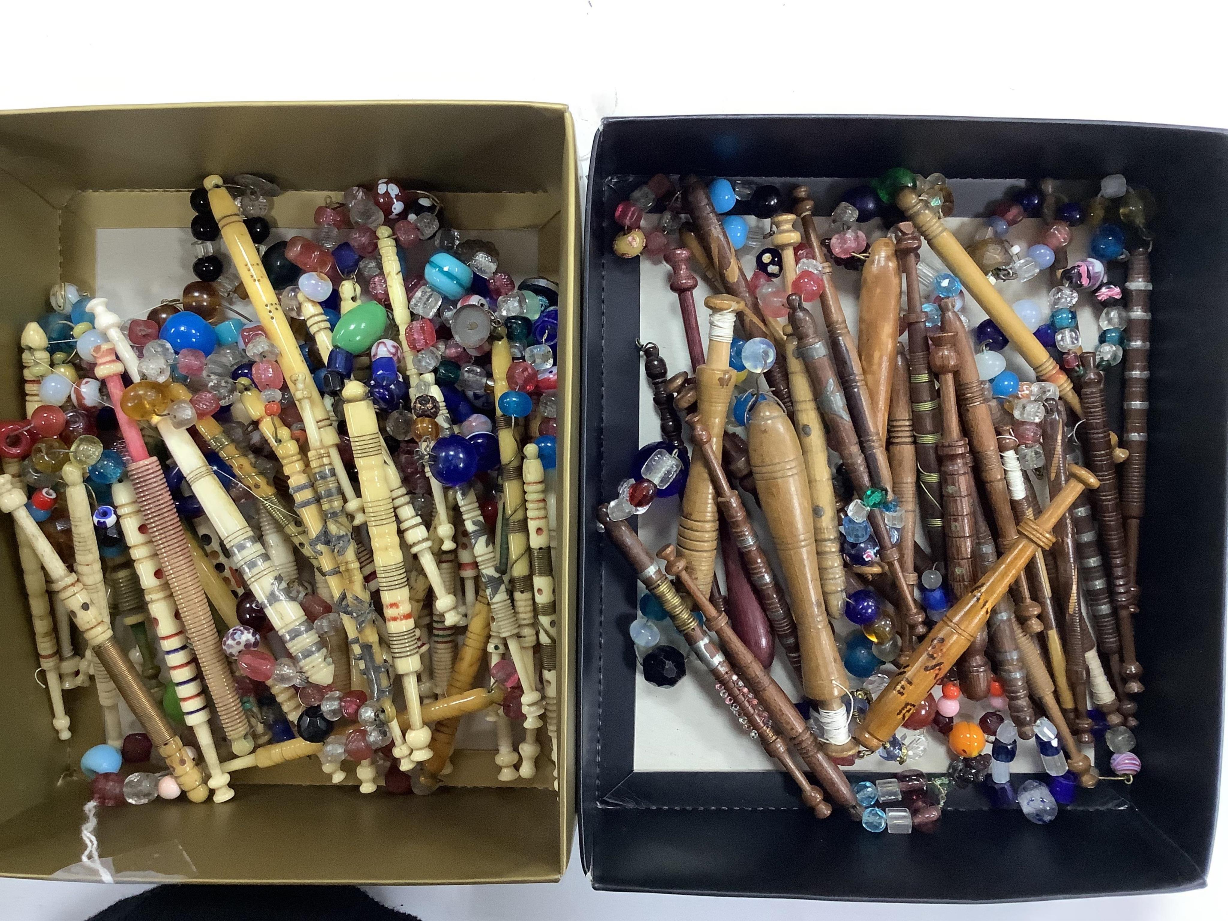 A collection of mostly 19th and 20th century ornate bone lace making bobbins, with coloured beaded ends, together with a similar smaller selection of wooden bobbins. Condition - good